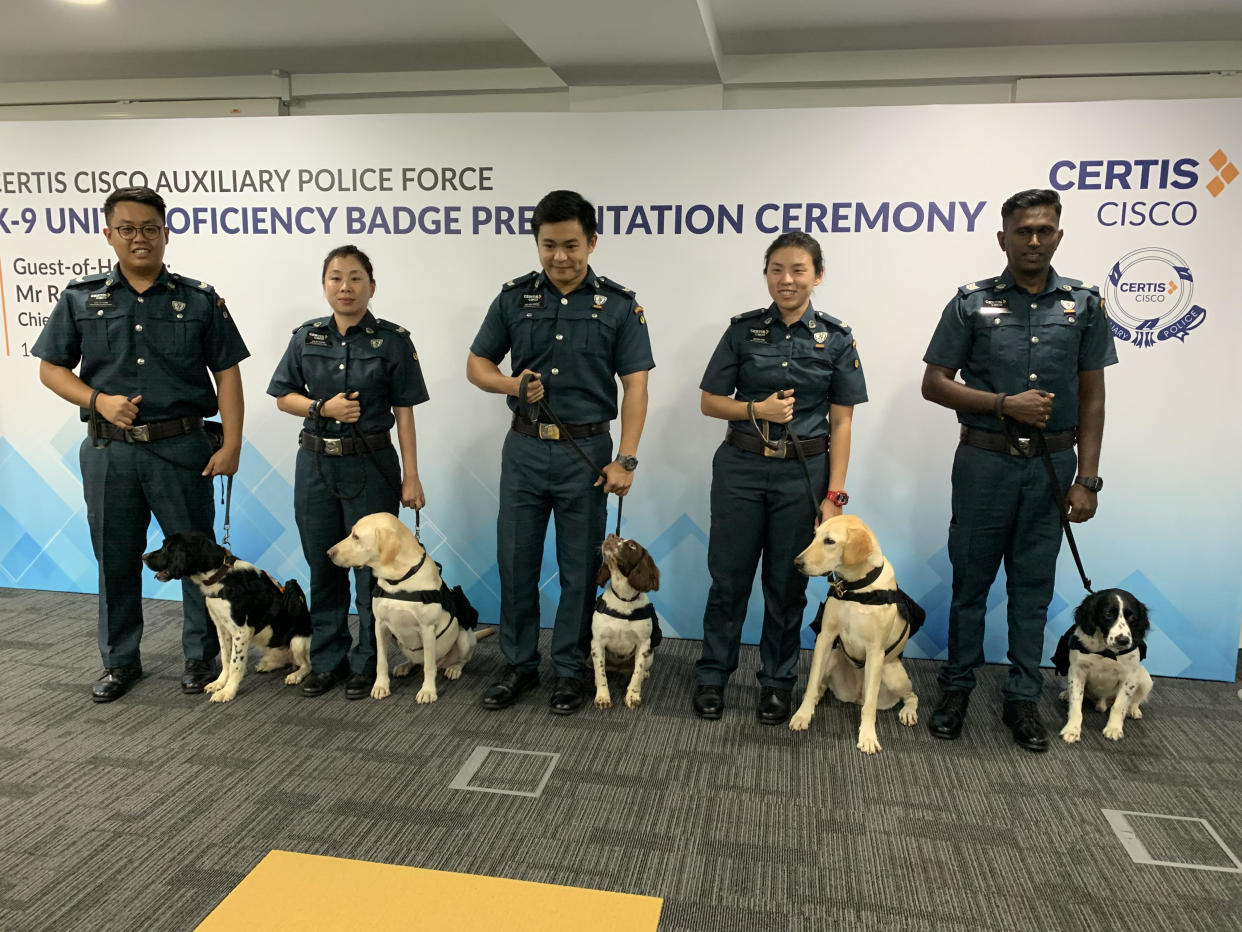 Certis Cisco Auxiliary police officers with their canine colleagues. From left: Corporal Lee Si Xian and Bonzo, corporal Chang Li Ting and Naomi, corporal Kelvin Wong Jia Wei and Peppe, corporal Lee Sin Nie and Aspa, and sergeant Yogeswaran Subramaniam and Turbo. (Photo: Amir Hussain/Yahoo News Singapore) 