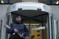 A French police officer stands guard in front of the main entrance of French television network TV5Monde headquarters in Paris, April 9, 2015. REUTERS/Benoit Tessier