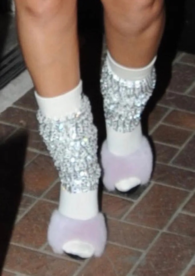 A closer look at Rihanna wearing fluffy light pink Saint Laurent LA 16 mules and Miu Miu&#x002019;s ribbed-knit wool socks featuring sequins and rhinestones. - Credit: Splash