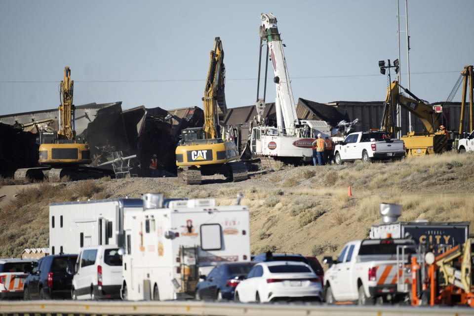 Workers toil to clear cars that derailed in an accident over Interstate 25 northbound, Monday, Oct. 16, 2023, north of Pueblo, Colo. (AP Photo/David Zalubowski)