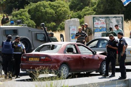 Israeli security forces gather at the scene where a female Palestinian was shot dead by Israeli troops at the entrance to Kiryat Arba near the West Bank city of Hebron June 24, 2016. REUTERS/Mussa Qawasma