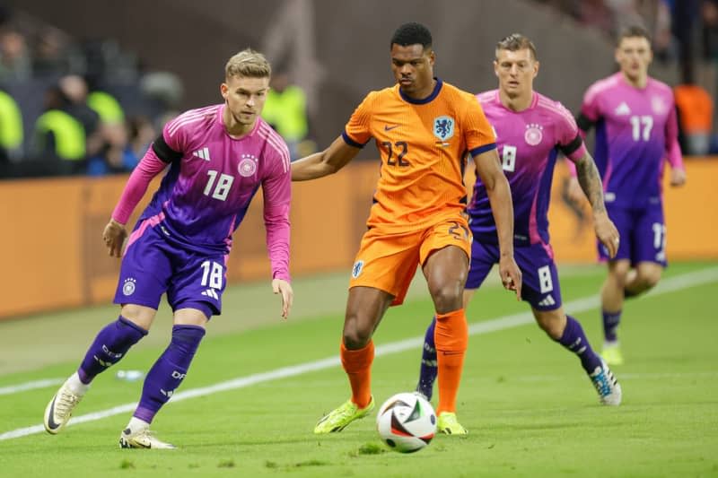 Germany's Maximilian Mittelstaedt (L) and the Netherlands' Denzel Dumfries (C) during the International Friendly soccer match between Germany and Netherlands at the Deutsche Bank Park stadium. Christian Charisius/dpa