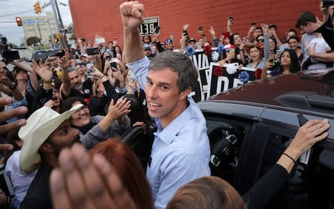 Beto O'Rourke pumps his fist for a cheering crowd before departing a campaign rally at the Alamo City Music Hall  - Credit: Chip Somodevilla/Getty Images