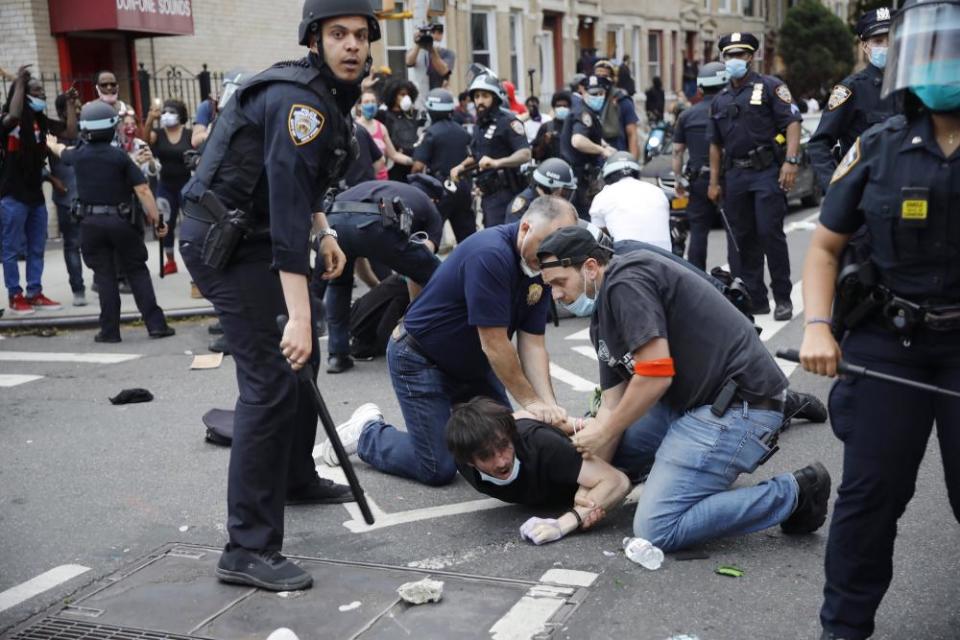 A New York City police officers arrest a protester in Brooklyn on 30 May