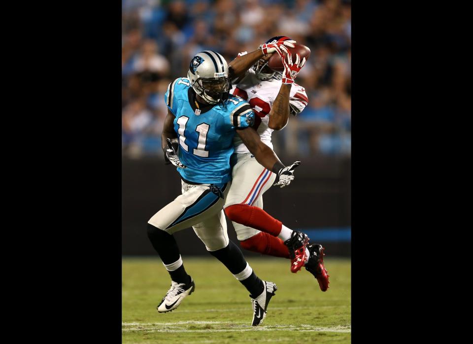 Jayron Hosley #28 of the New York Giants intercepts a pass in the second quarter against Brandon LaFell #11 of the Carolina Panthers at Bank of America Stadium on September 20, 2012 in Charlotte, North Carolina.  