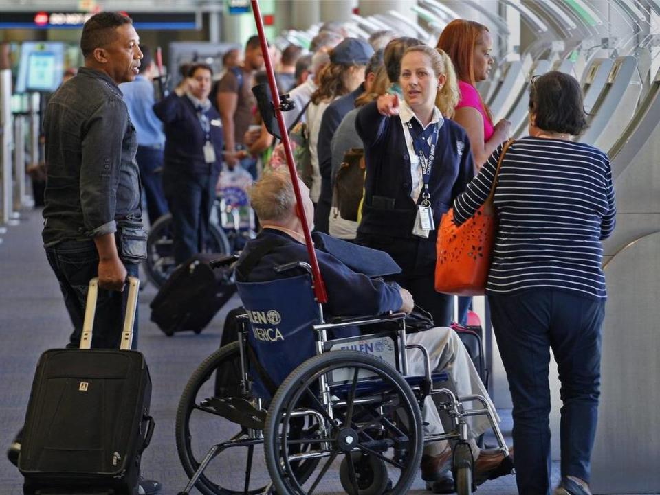 Miami International Airport staff give instructions to international travelers before the arrive in the immigration zone.