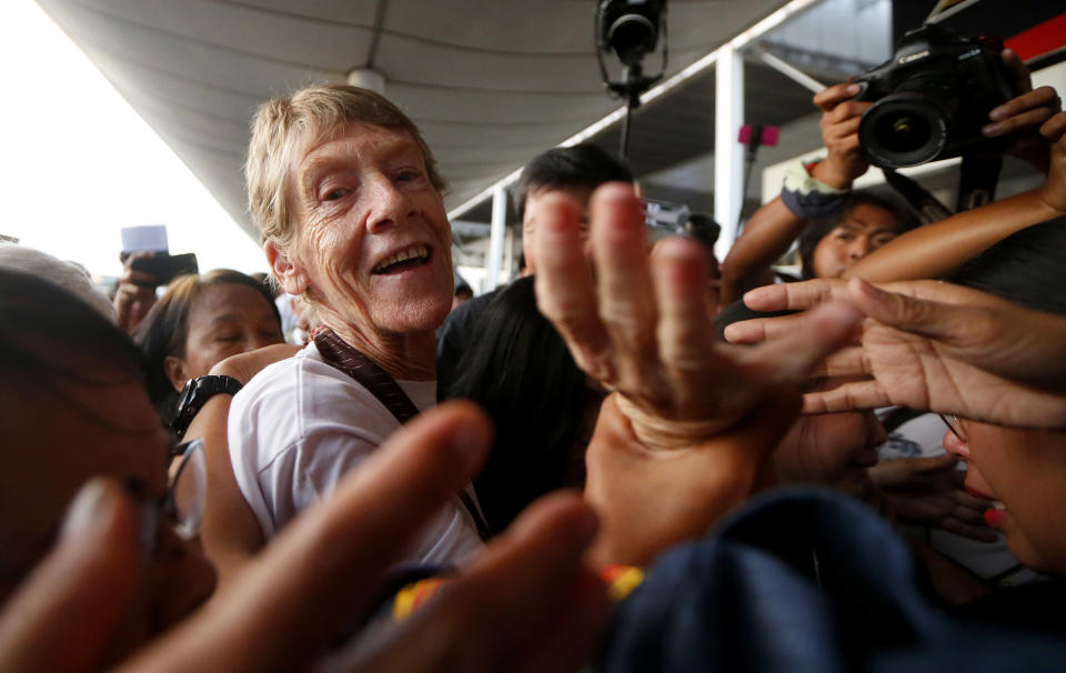 Australian Roman Catholic nun Sister Patricia Fox reaches out to bid goodbye to supporters as she is escorted to the Ninoy Aquino International Airport for her flight to Australia Saturday, Nov. 3, 2018, in Manila, Philippines. Sister Fox decided to leave after 27 years in the country after the Immigration Bureau denied her application for the extension of her visa. Sr. Fox called on Filipinos to unite and fight human rights abuses ahead of her forced departure from the country. (AP Photo/Bullit Marquez)