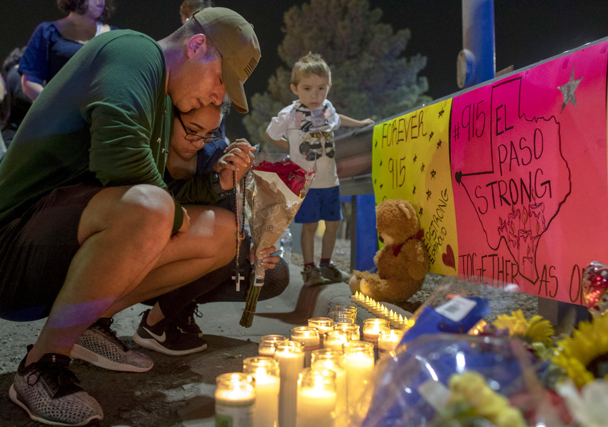 Rene Aguilar and Jackie Flores pray at a makeshift memorial for the victims of Saturday's mass shooting at a shopping complex in El Paso, Texas, Sunday, Aug. 4, 2019. (Photo: Andres Leighton/AP)