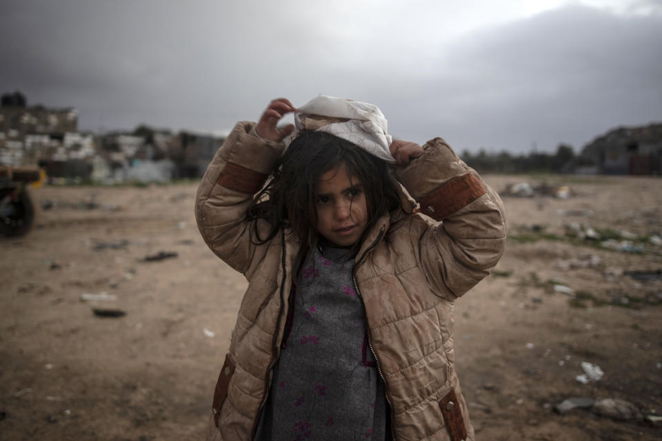 A Palestinian girl stands outside her family house during a cold weather spell in a slum on the outskirts of the Khan Younis refugee camp, southern Gaza Strip, Wednesday, Jan. 19, 2022. (AP Photo/Khalil Hamra)