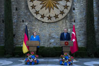 Turkey's President Recep Tayyip Erdogan, right, talks to journalists next to German Chancellor Angela Merkel during a joint news conference following their meeting at Huber vila, Erdogan's presidential resident, in Istanbul, Turkey, Saturday, Oct. 16, 2021. The leaders discussed Ankara's relationship with Germany and the European Union as well as regional issues including Syria and Afghanistan. (AP Photo/Francisco Seco)