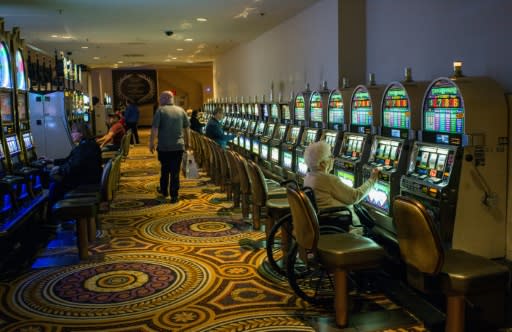 A woman plays the slot machine in a near empty casino in Atlantic City, where the closure of some casinos in recent years contributed to a sharp fall in tax revenue