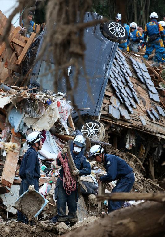 Police officers search for missing people, one day after a landslide hit a residential area in Hiroshima, western Japan on August 21, 2014
