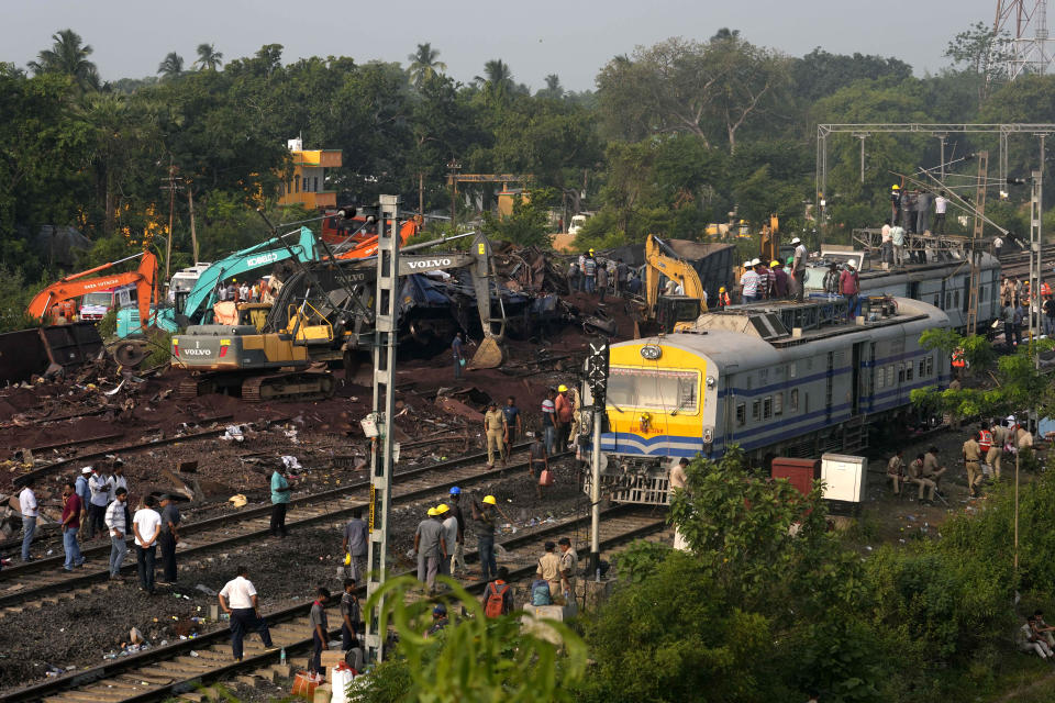 People watch the site where trains that derailed, in Balasore district, in the eastern Indian state of Orissa, Sunday, June 4, 2023. Indian authorities end rescue work and begin clearing mangled wreckage of two passenger trains that derailed in eastern India, killing over 300 people and injuring hundreds in one of the country’s deadliest rail crashes in decades. (AP Photo/Rafiq Maqbool)