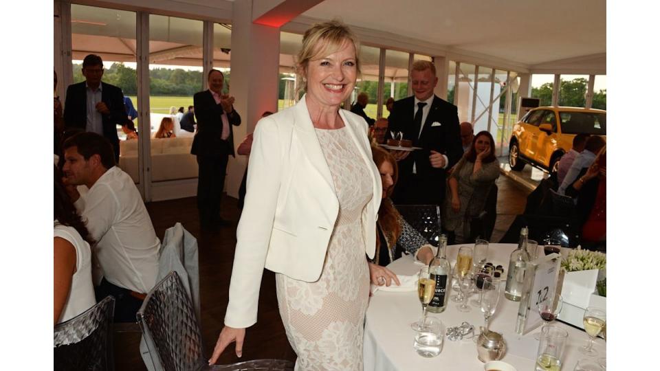 Carol Kirkwood in a white lace dress at a dinner party