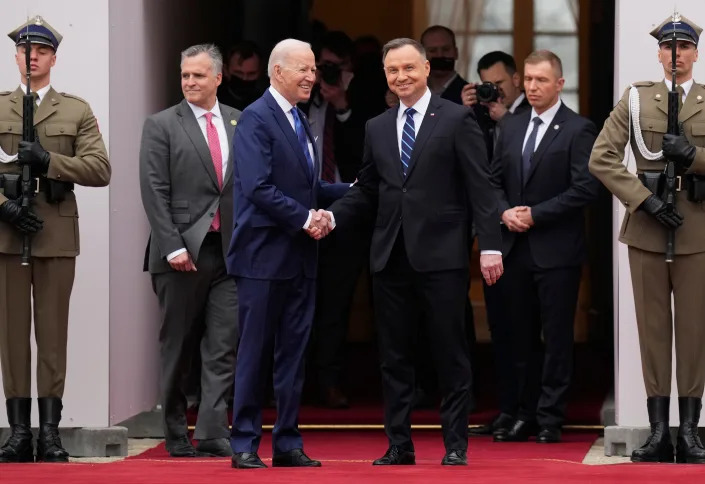 U.S. President Joe Biden, third from left, and Polish President Andrzej Duda shake hands during a military welcome ceremony at the Presidential Palace in Warsaw, Poland, on Saturday, March 26, 2022.