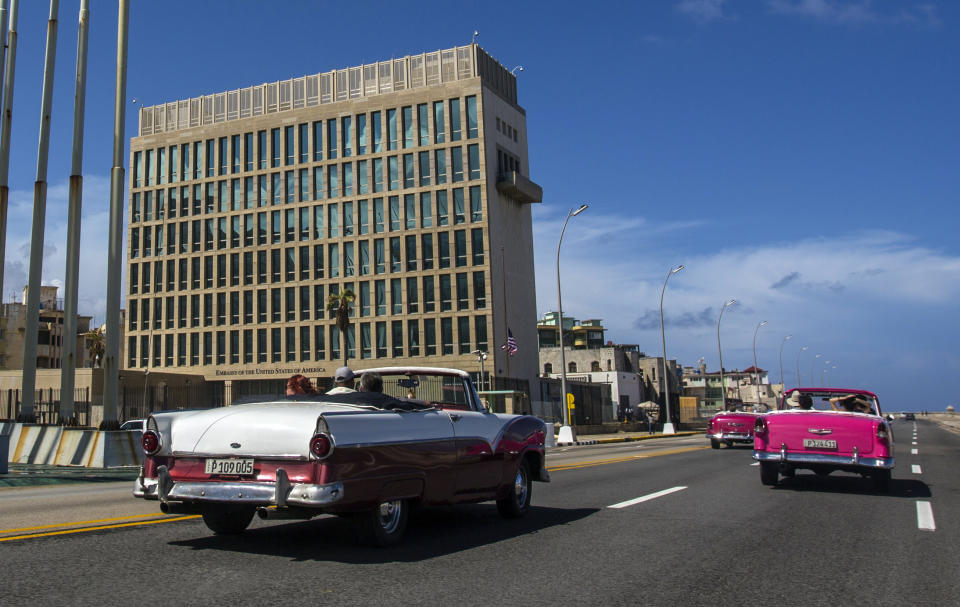 FILE - Tourists ride classic convertible cars on the Malecon beside the United States Embassy in Havana, Cuba, Oct. 3, 2017. The Pentagon confirms that a senior Defense Department official who attended last years’ NATO summit in Lithuania had symptoms similar to those reported by U.S. officials who have experienced “Havana syndrome." The syndrome is a still-unexplained set of symptoms that includes piercing head or ear pain. Current intelligence assessments have found that it is unlikely that Havana syndrome attacks were conducted by a foreign adversary. But intelligence agencies have varying degrees of confidence in that assessment. (AP Photo/Desmond Boylan, File)