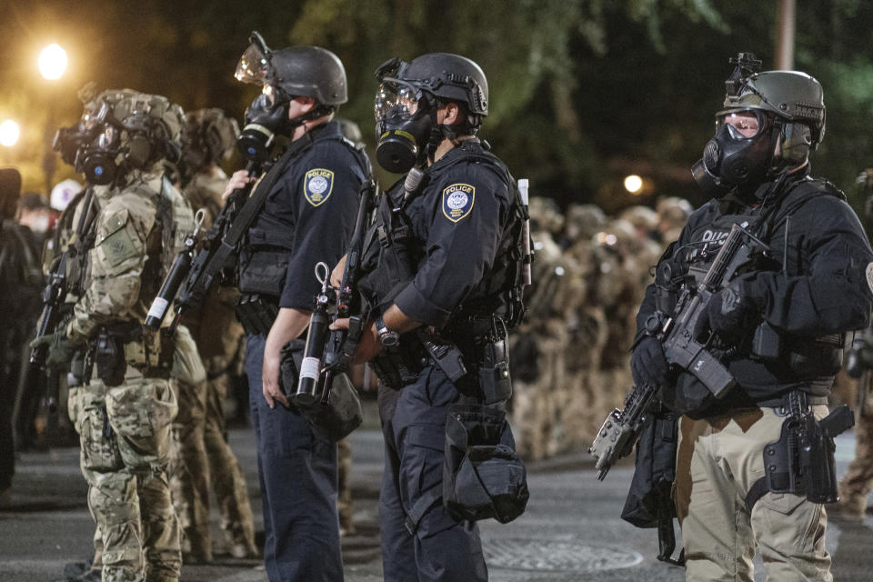 In this photo provided by Doug Brown, agents from different components of the Department of Homeland Security are deployed to protect a federal courthouse in Portland, Ore., on Sunday, July 5, 2020. Protesters who have clashed with authorities in Portland are facing off not just against city police but a contingent of federal agents who reflect a new priority for the Department of Homeland Security: preventing what President Donald Trump calls "violent mayhem." The agents clad in military-style uniforms include members of an elite Border Patrol tactical unit, and their deployment to protect federal buildings and monuments is a departure for an agency created to focus on threats from abroad. (Doug Brown via AP)