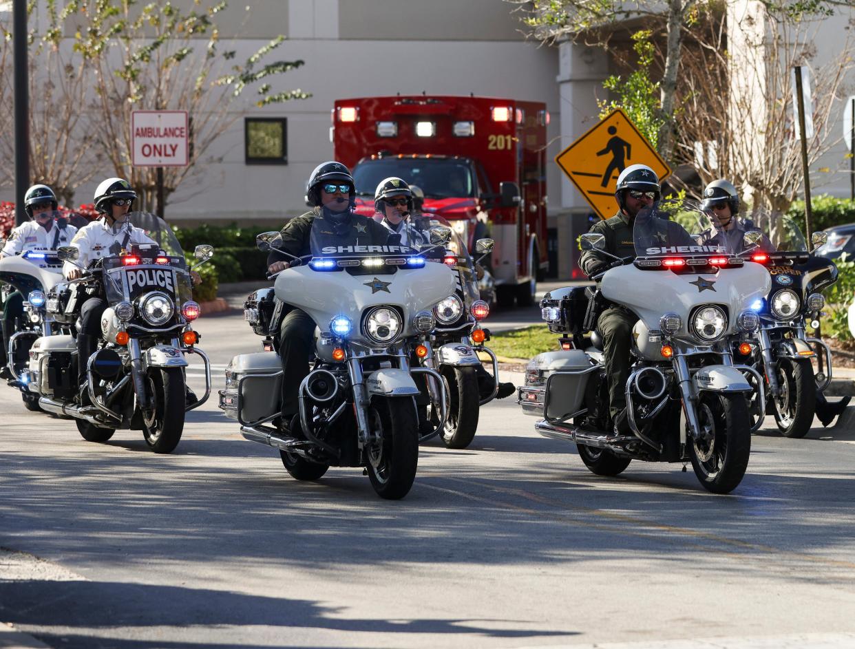 Law enforcement escorts an ambulance carrying Florida Highway Patrol Trooper Zachary Fink's body from Lawnwood Hospital on Friday, Feb. 2, 2024. Fink died in crash on I-95 in Port St. Lucie Friday morning.