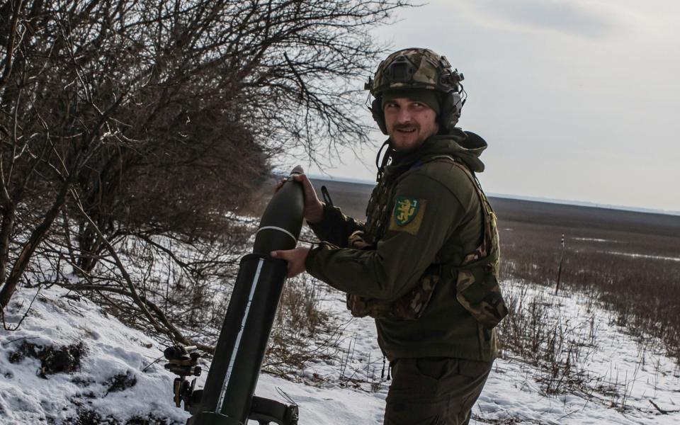 A Ukrainian soldier loads a shell into a mortar before firing towards Russian troops - STRINGER/REUTERS