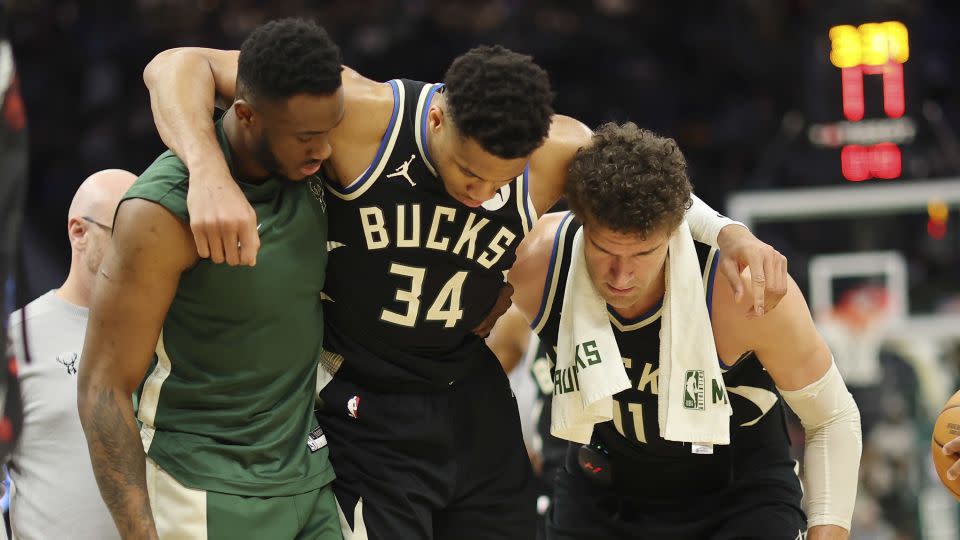 Antetokounmpo is helped off the court by teammates after suffering a calf injury. - Stacy Revere/Getty Images