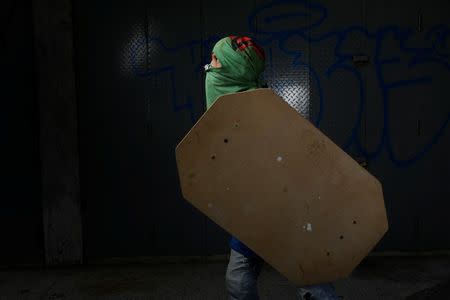 A demonstrator holding a rudimentary shield, poses for a picture before a rally against Venezuelan President Nicolas Maduro's government in Caracas, Venezuela, May 27, 2017. He said: "I protest for a better country. I want a better future for me and my family." REUTERS/Carlos Garcia Rawlins