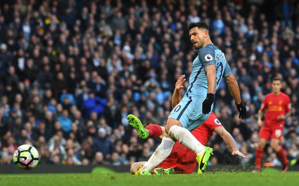 <p>Sergio Aguero slides home the ball as City level with Liverpool </p>