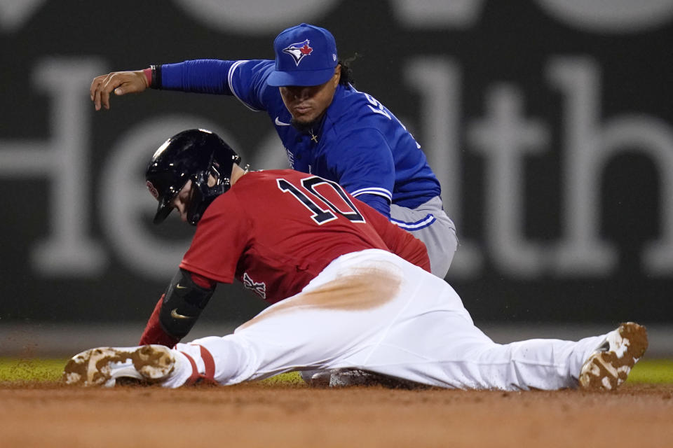 Boston Red Sox's Trevor Story (10) beats the tag by Toronto Blue Jays second baseman Santiago Espinal (5) on his RBI double during the third inning of a baseball game, Tuesday, April 19, 2022, at Fenway Park in Boston. (AP Photo/Charles Krupa)