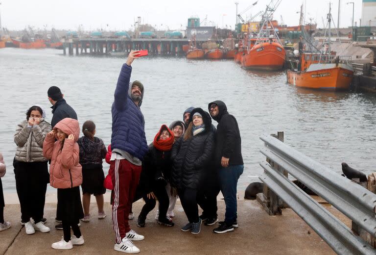 A pesar del frío y la lluvia, los turistas aprovecharon la banquina marplatense para las fotos y las comidas con pescados y mariscos