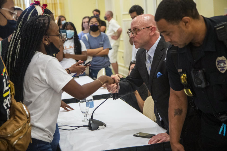 Taliajah Vann, president of the campus Black Student Movement shakes hands with Gene Davis, vice chairman of the UNC-Chapel Hill Board of Trustees, as they agree to meet to discuss concerns after the board voted to approve tenure for distinguished journalist Nikole Hannah-Jones Wednesday, June 30, 2021 at Carolina Inn in Chapel Hill, N.C. (Travis Long/The News & Observer via AP)