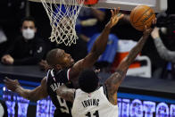 Brooklyn Nets guard Kyrie Irving, right, shoots as Los Angeles Clippers center Serge Ibaka defends during the first half of an NBA basketball game Sunday, Feb. 21, 2021, in Los Angeles. (AP Photo/Mark J. Terrill)