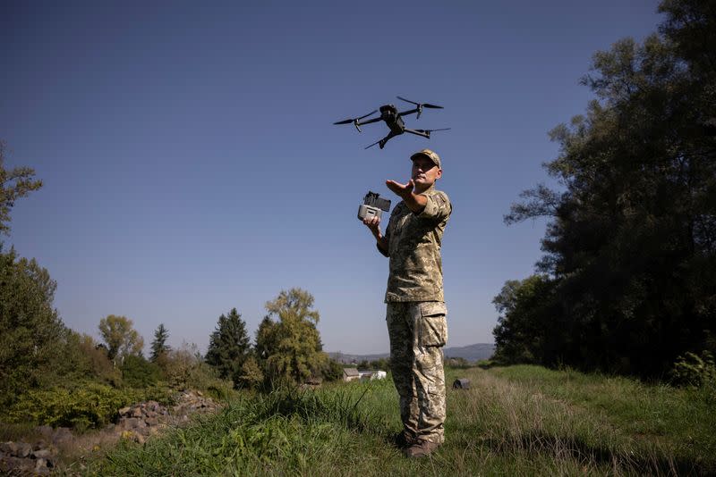 Ukrainian border guard launches a drone he uses to survey the border to Romania in Tyachiv