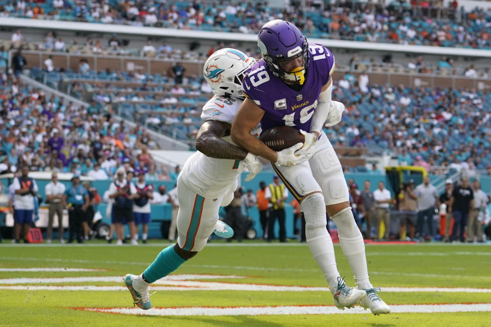 Minnesota Vikings wide receiver Adam Thielen (19) scores a touchdown under pressure from Miami Dolphins cornerback Xavien Howard (25), during the second half of an NFL football game, Sunday, Oct. 16, 2022, in Miami Gardens, Fla. (AP Photo/Lynne Sladky)