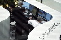 Workers monitor stock prices on an electric screen during the first trading session of the year at the Tokyo Stock Exchange in Tokyo Monday, Jan. 6, 2020, in Tokyo. Shares are skidding in Asia, with Tokyo's Nikkei 225 index down 2 percent on concern over escalating tensions in the Middle East following the killing by a U.S. air strike of an Iranian general.(AP Photo/Eugene Hoshiko)