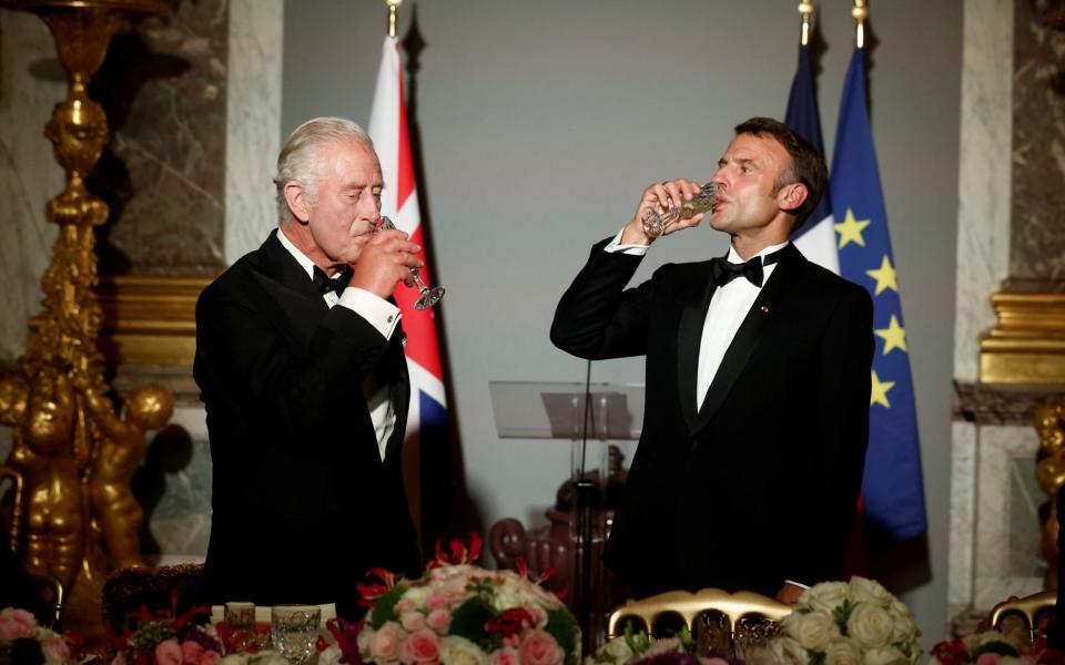 President Emmanuel Macron and King Charles make a toast during a state dinner in the Hall of Mirrors (Galerie des Glaces) at Versailles