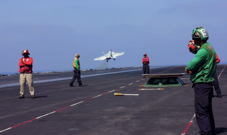 A fighter plane lifts off from the USS George H.W. Bush. 