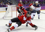 Jayna Hefford of Canada (16) loses her footing while sealing off the puck from Hilary Knight of the United States (21) during the first period of the women's gold medal ice hockey game at the 2014 Winter Olympics, Thursday, Feb. 20, 2014, in Sochi, Russia. (AP Photo/Mark Humphrey)