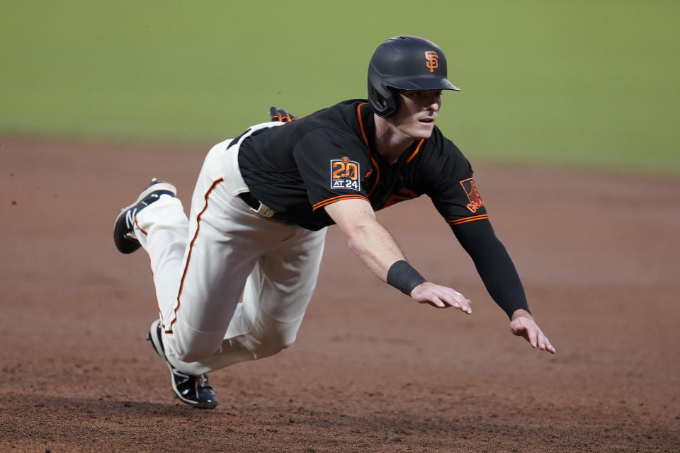 San Francisco Giants' Mike Yastrzemski dives back to first base during the third inning of a baseball game against the San Francisco Giants in San Francisco, Saturday, Sept. 26, 2020. (AP Photo/Eric Risberg)