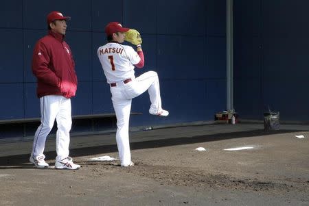 Yoshinori Sato (L), a pitching coach for the Rakuten Golden Eagles, coaches rookie Yuki Matsui at Muscat Stadium in Kurashiki, western Japan March 8, 2014. REUTERS/Junko Fujita