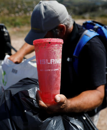 Miguel Lacerda, 62, shows a plastic cup that traveled to Portugal from a beach bar in Florida at the coast near Sintra, Portugal May 22, 2019. REUTERS/Rafael Marchante