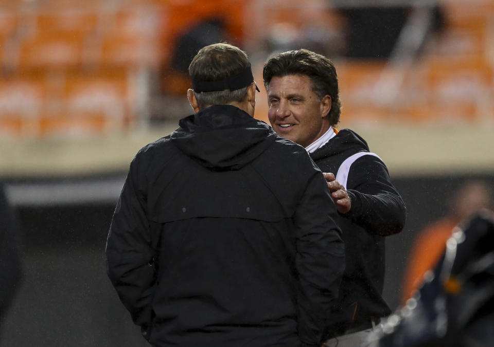 Oklahoma State coach Mike Gundy, right, meets Cincinnati coach Scott Satterfield before an NCAA college football game Saturday, Oct. 28, 2023, in Stillwater, Okla. (AP Photo/Mitch Alcala)