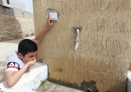Boy drinks water during a water shortage in Tripoli