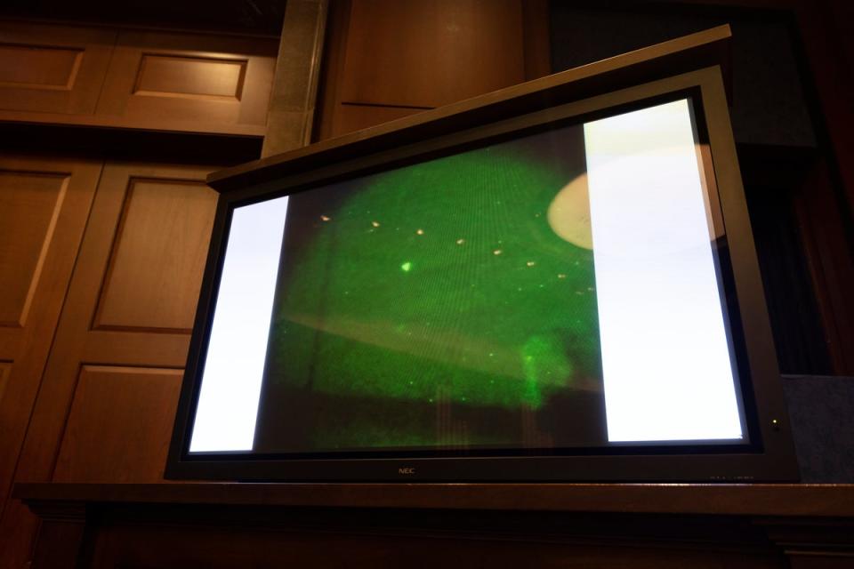 An ‘unidentified aerial phenomena’, commonly referred to as a UFO, is shown on a TV monitor during a House hearing (EPA)