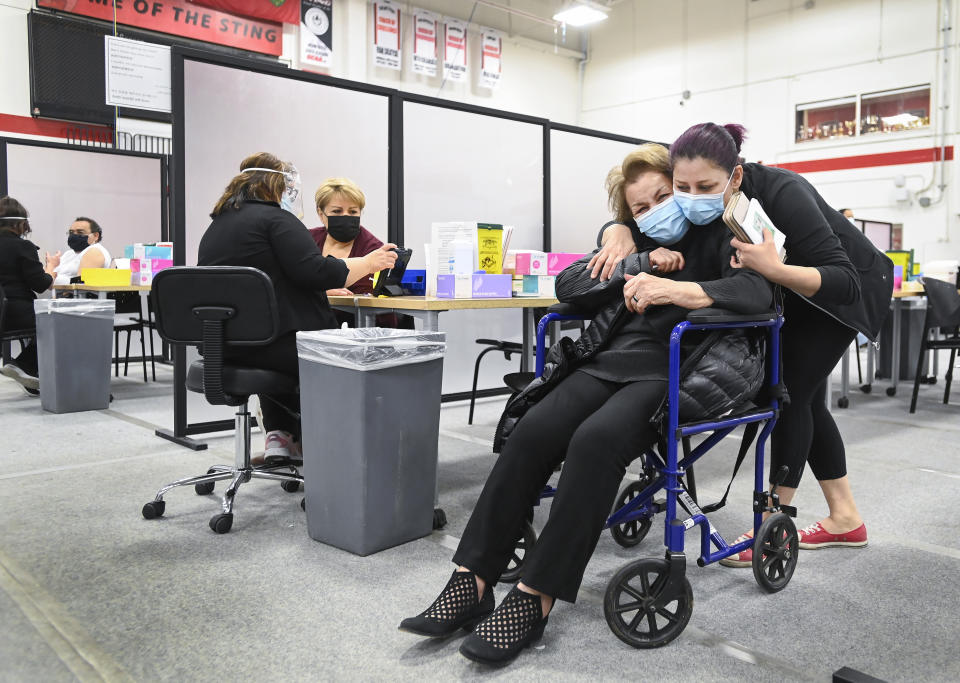 Manda Zand, right, hugs her grandmother Farang Ahmadkorour, 92, after she received her COVID-19 vaccine at the Seneca College mass vaccination site during the coronavirus pandemic in Toronto, Tuesday, April 6, 2021. (Nathan Denette/The Canadian Press via AP)