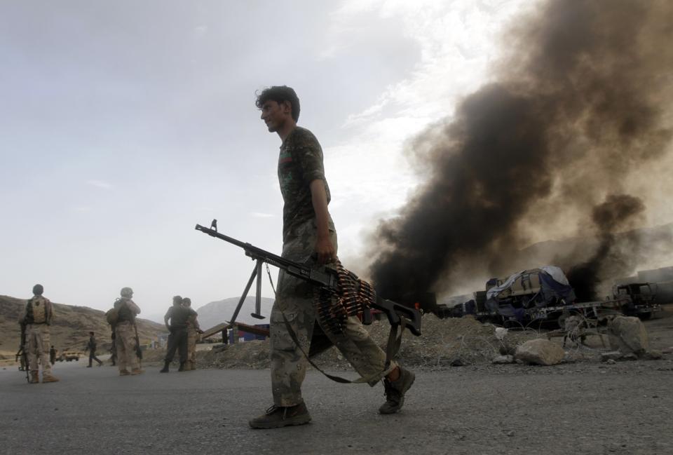 Afghan security forces leave the site of burning NATO supply trucks after an attack by militants in the Torkham area near the Pakistani-Afghan in Nangarhar Province June 19, 2014. (REUTERS/Parwiz)