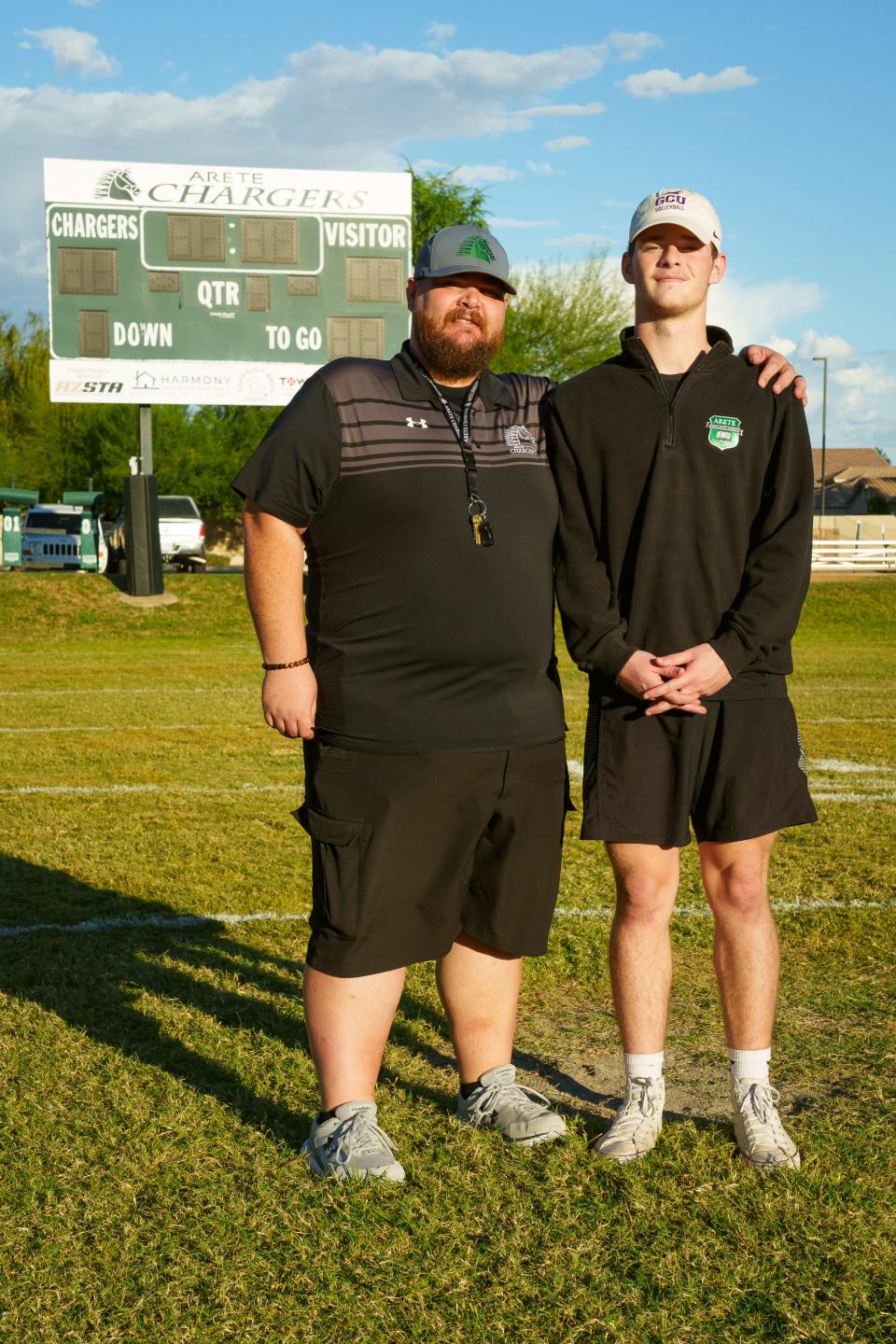 Aiden Wander (right), and his father Jeremy Wander (left), pose for a portrait at the Arete Prep Cangers' football field on Oct. 10, 2022, in Gilbert.