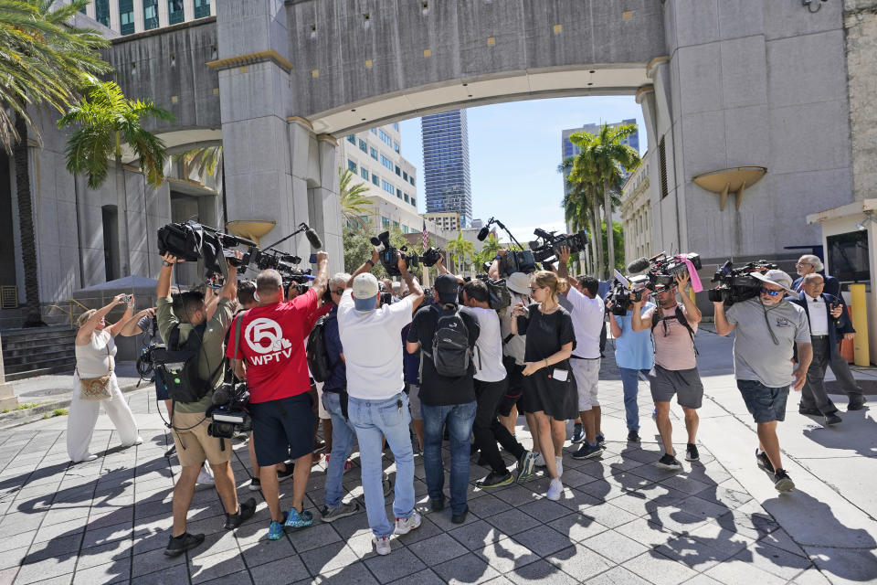 Journalists surround Carlos De Oliveira, an employee of Donald Trump's Mar-a-Lago estate, as he leaves a court appearance at the James Lawrence King Federal Justice Building, Monday, July 31, 2023, in Miami. De Oliveira, Mar-a-Lago's property manager, was added last week to the indictment with Trump and the former president's valet, Walt Nauta, in the federal case alleging a plot to illegally keep top-secret records at Trump's Florida estate and thwart government efforts to retrieve them. (AP Photo/Wilfredo Lee)