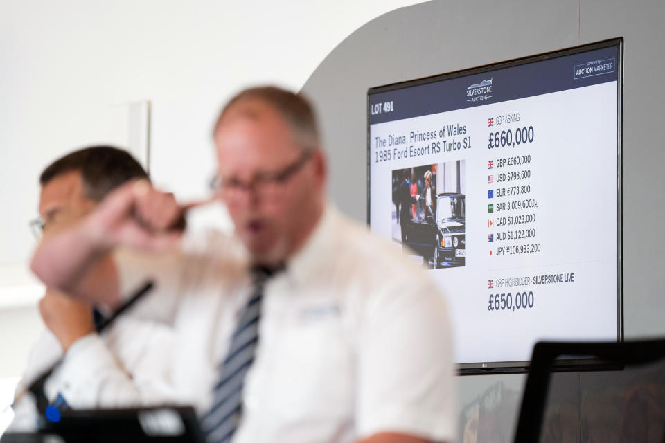 Auctioneer Jonathan Humbert takes bids for the 1985 Ford Escort RS Turbo previously owned by Diana, Princess of Wales, at the Silverstone Race Circuit near Towcester, Northamptonshire, England, and sold for 650,000 pounds. Aug. 27, 2022. / Credit: Joe Giddens/PA Image/Getty Images