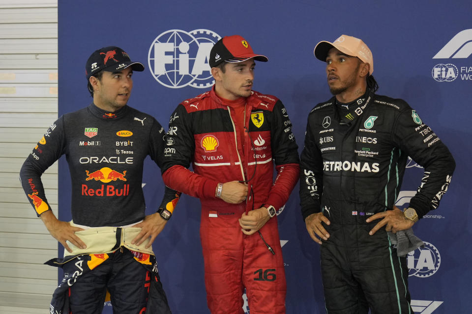 Ferrari driver Charles Leclerc of Monaco, center, who clocked the fastest time, talks with Red Bull driver Sergio Perez of Mexico, left, second fastest, and Mercedes driver Lewis Hamilton of Britain, right, third fastest, after the qualifying session at the Singapore Formula One Grand Prix, at the Marina Bay City Circuit in Singapore, Saturday, Oct. 1, 2022. (AP Photo/Vincent Thian)
