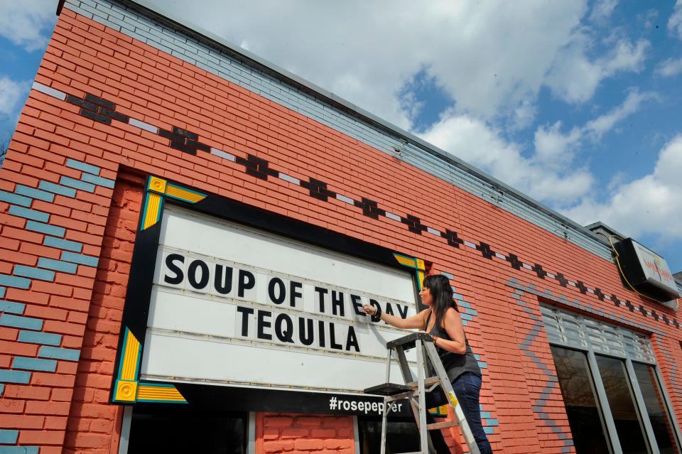 Rosepepper owner Andrea Chaires changes out the marquee in front of the restaurant on Eastland Avenue. The sign has gained notoriety for its clever quips.