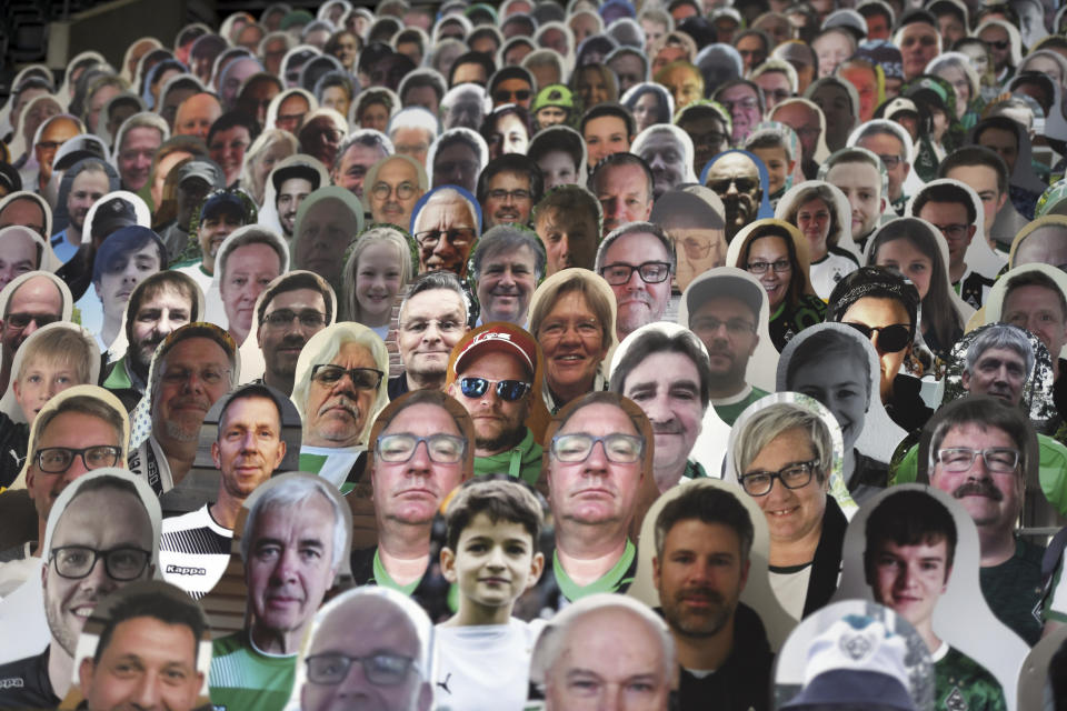 Cardboard pictures of fans are placed in the stands prior to the German Bundesliga soccer match between Borussia Moenchengladbach and Leverkusen, in Moenchengladbach, Germany, Saturday, May 23, 2020. (Ina Fassbender Pool Photo via AP)